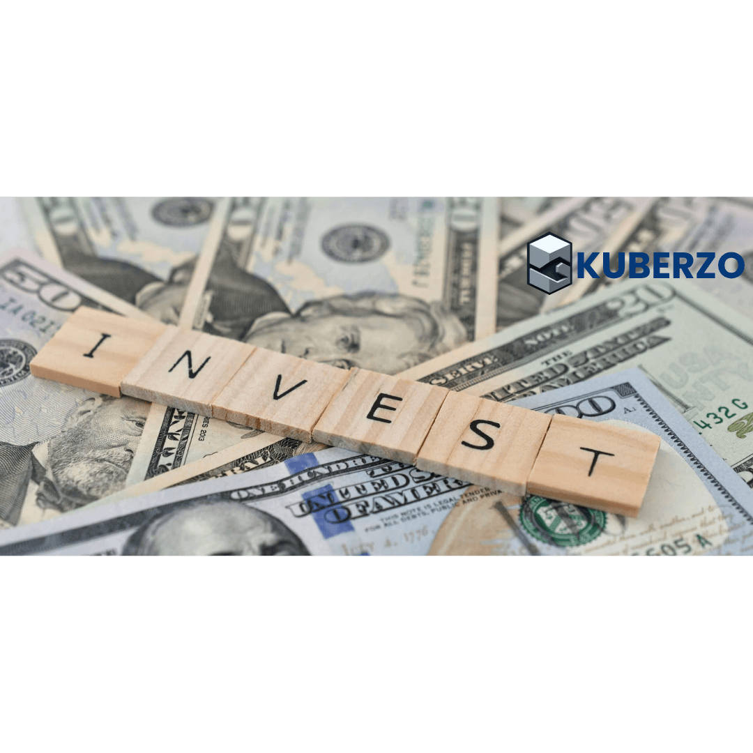 Wooden letter blocks spelling "INVEST" placed on scattered U.S. dollar bills, symbolizing investing, wealth creation, financial planning, and investment opportunities. The Kuberzo logo is displayed in the top-right corner.